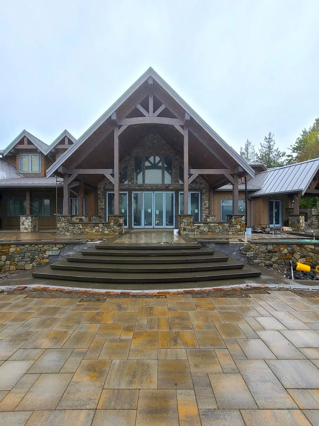 Wide angle view of a grand entryway in Puyallup with five curved, smooth-finish concrete steps leading to a home.