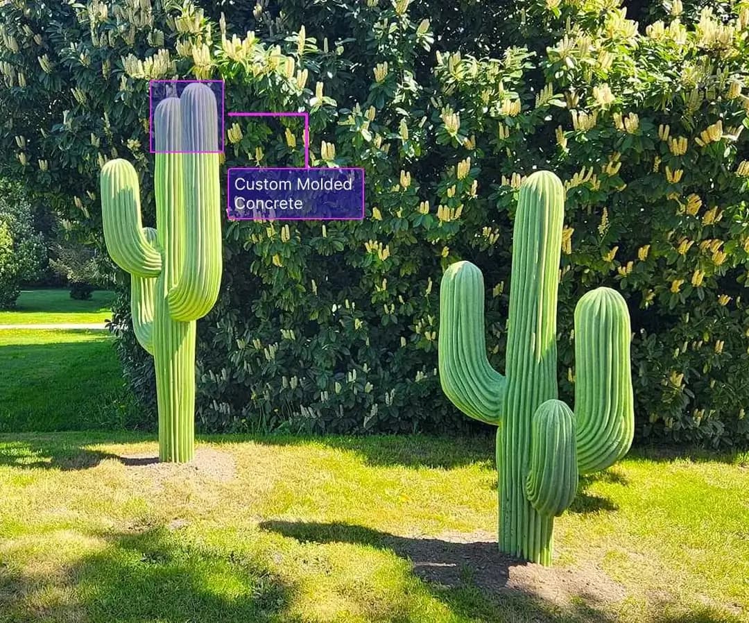 Two custom molded concrete Saguaro cactus sculptures standing in a manicured lawn in Puyallup, WA.