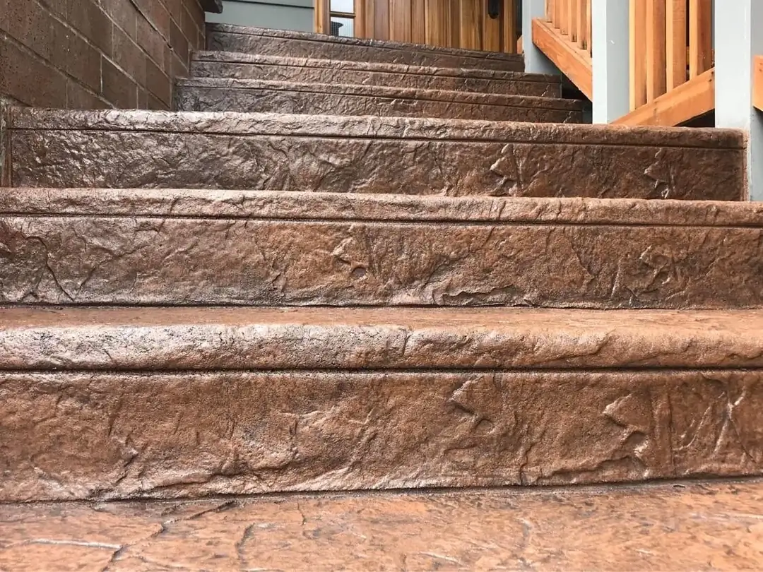 Detailed close-up of stamped concrete stair treads showing the deep, non-slip stone texture.