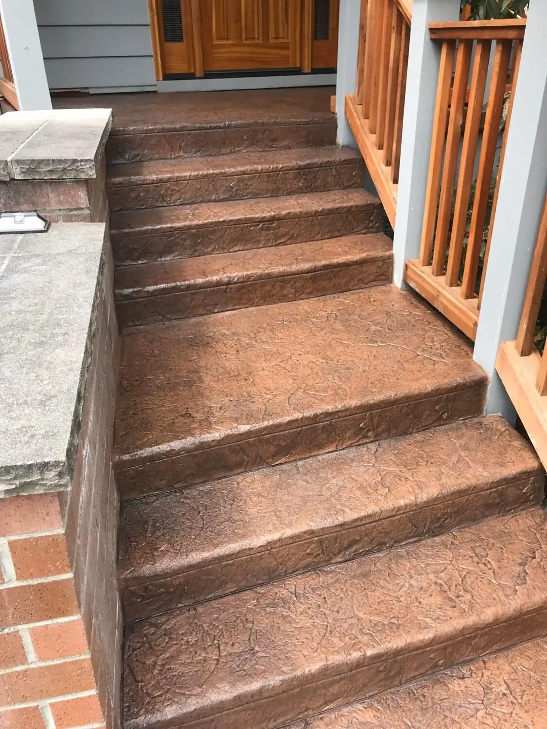Top-down perspective of a stamped concrete stairway leading to a residential front porch.