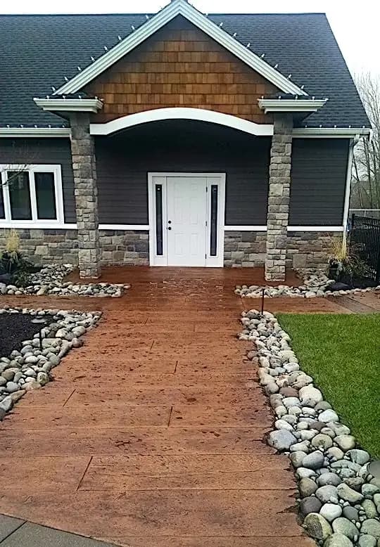 Front view of a home in Bellevue with a new stamped concrete walkway in a reddish-brown wood plank pattern.