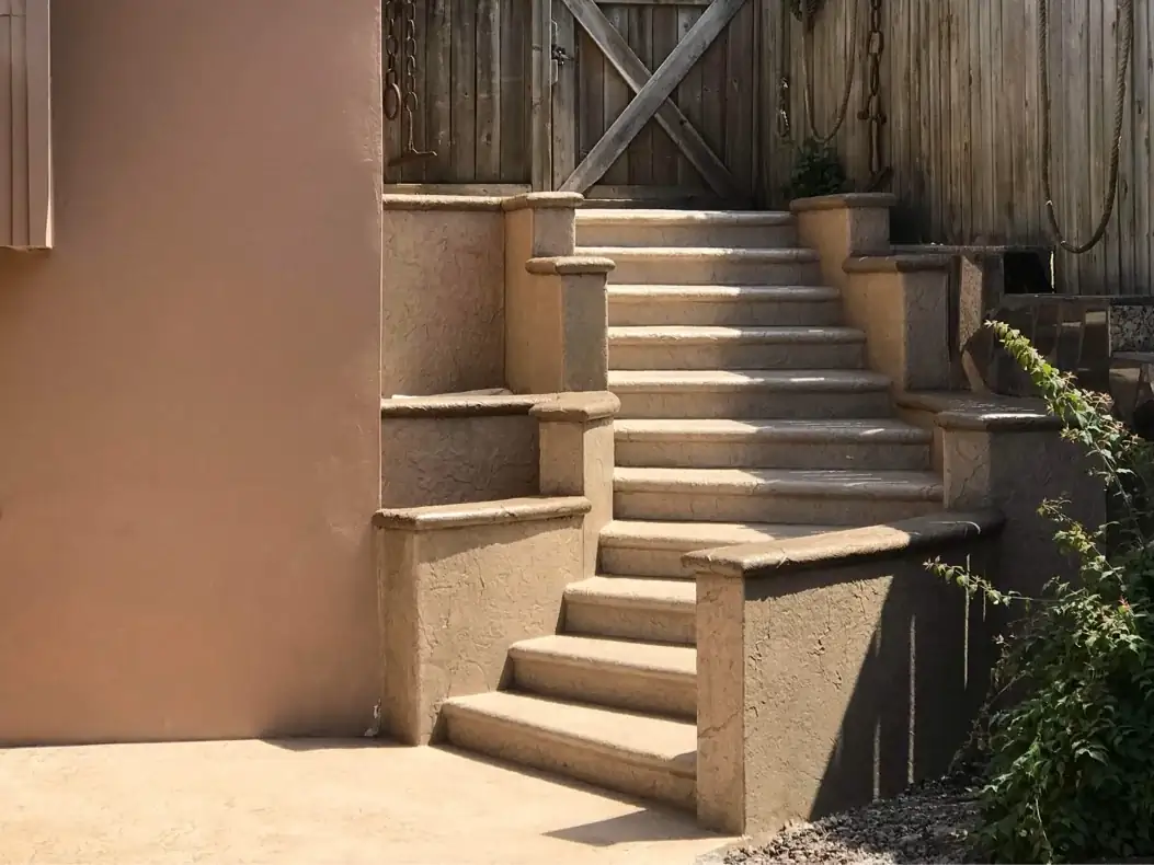 Full view of a custom stamped concrete staircase with tiered retaining walls and integrated planters in Puyallup, WA.
