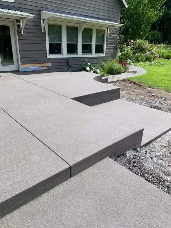 A multi-level sand finish concrete patio with integrated steps and clean saw-cut joints in Waller, WA.